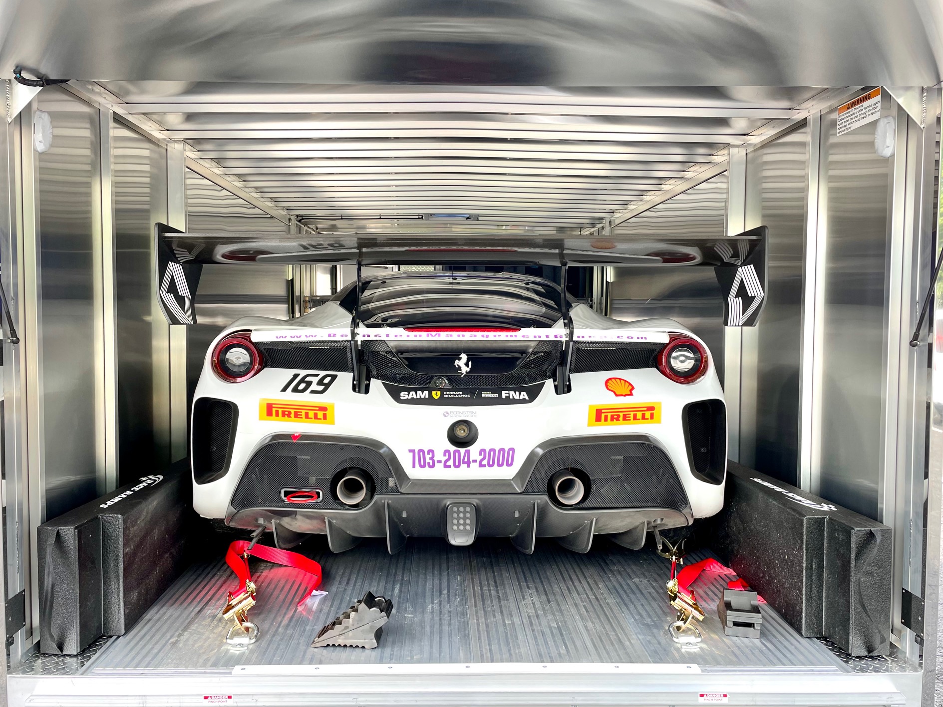 Ferrari Challenge racecar loaded in enclosed trailer, rear view